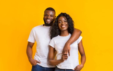 Genç Afro Çift Sarılma, aşk havada, sarı arka plan