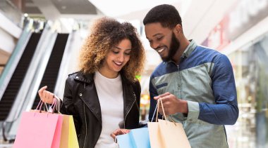 Mutlu Afrikalı adam alışveriş çantalarını Mall Merkezi, Panorama onun kız arkadaşı satın gösteren