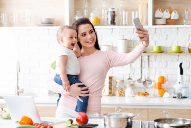 Mutfak selfie'si. Bin yıllık anne cep telefonuselfie alarak, kamera, boş alan gülümseyerek