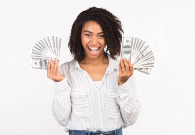 Kolay Para, İkramiye. Heyecanlı bir Afrikalı Amerikalı kadının elinde beyaz arka planda izole edilmiş bir sürü para var.