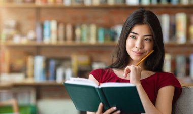 Gelecek Planları 'nı düşünüyorum. Kafe 'de Notepad' le oturan dalgın Asyalı kız, boş alanı olan bir panorama.