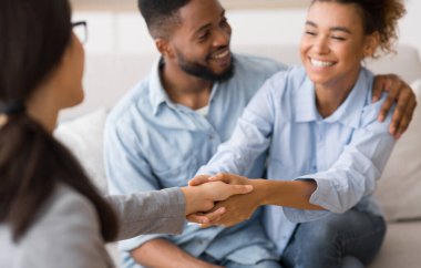 Profesyonel yardım için şükran. Mutlu afro çift ve psikolog etkili bir tedaviden sonra ofiste el sıkışma. Seçici odaklama