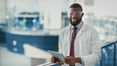 İş kıyafetleri içindeki mutlu siyah adam ve koruyucu gözlükler takan tıbbi bilimci dijital tablet kullanan, verileri analiz eden, iş yerinde poz veren, kopya alanı olan bir panorama. İş ve Meslek kavramı