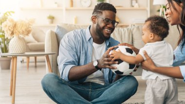 Sevgi dolu bir aile. Neşeli siyah baba ve annenin sevimli küçük oğullarıyla oynadığı, babalarının diş telleri ve gözlükleriyle çocuklara top verdiği, oturma odasındaki halının üzerinde oturduğu,