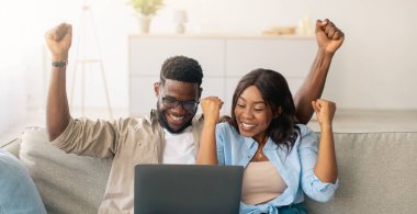 Öyle mi? Duygusal heyecanlı siyah çift online galibiyeti kutluyor, büyük bir anlaşma ya da iş başarısı, bilgisayar, neşeli bayan ve erkek titrek yumruklar kaldırıyor ve kanepede oturan ekrana bakıyor.