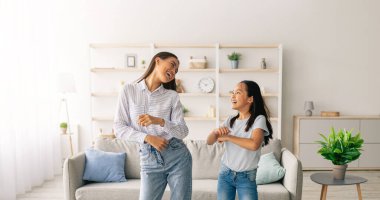 Asyalı bir annenin evde tatlı kızıyla müzik eşliğinde dans etmesi, birlikte eğlenmesi. Anne ve oğlu birlikte en sevdiği şarkıyı dinliyorlar, oturma odasında oynaşıyorlar.