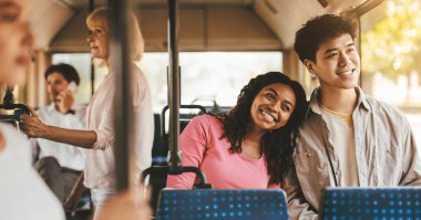 Genç bir çift otobüs sürerken gülümsüyor, birbirlerine eşlik etmekten zevk alıyorlar. Arkadaşlar arka planda görülür, canlı bir atmosfer yaratırlar. Güneş ışığı otobüs pencerelerinden geçer..