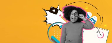 Neşeli bir çocuk parlak sarı bir arka planda gözlük tutarken gülümsüyor. Çocuğun etrafındaki çeşitli okul malzemeleri öğrenme ortamının eğlenceli olduğunu gösteriyor..