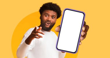 Neşeli bir suratı olan biri akıllı telefonu vitrin için kaldırır. Parlak sarı arka plan sahneye enerji katıyor ve mobil teknolojiyi sergilemek için eğlenceli bir atmosfer yaratıyor..