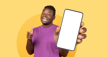 Mor gömlekli genç bir adam, elinde boş ekranlı akıllı bir telefonla şakacı poz veriyor..