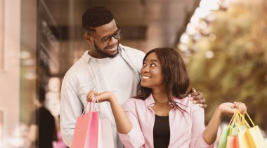 Aşık çift. Neşeli, yakışıklı, Afro-Amerikan bir adam. Renkli alışveriş torbaları tutan ve ona bakan kız arkadaşına ya da karısına sarılıyor. Mutlu siyah aşıklar dışarıda eğleniyor ve gülüyorlar.