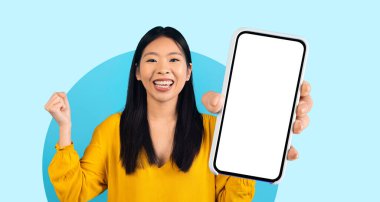 Sarı bluzlu neşeli bir kadın boş bir akıllı telefon ekranını heyecan içinde sol eliyle sunuyor. Arka plan basit, parlak mavi bir renktir..