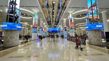 Dubai, BİRLİK ARAB EMIRATESİ. 15 Eylül 2023. Dubai 'deki uzun, hareketli havaalanı koridoru büyük bilgi ekranlarıyla dolu.