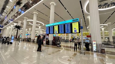 Dubai Havaalanı 'nda büyük bir bagaj bilgi ekranı, hareketli nakliye merkezinde bir işaret.