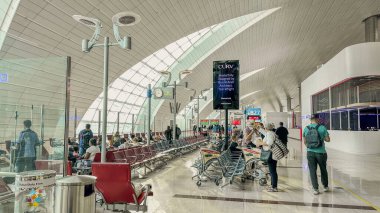 DUBAI, UAE.16 EYLÜL 2023 kalkış kapısında sabırla oturan gezginler, pasaportları ellerinde, maceralarının bir sonraki bölümüne girmeye hazırlar.