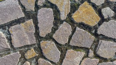 Nüanslı toprak tonları olan engebeli bir taş duvarın karmaşık detayları.