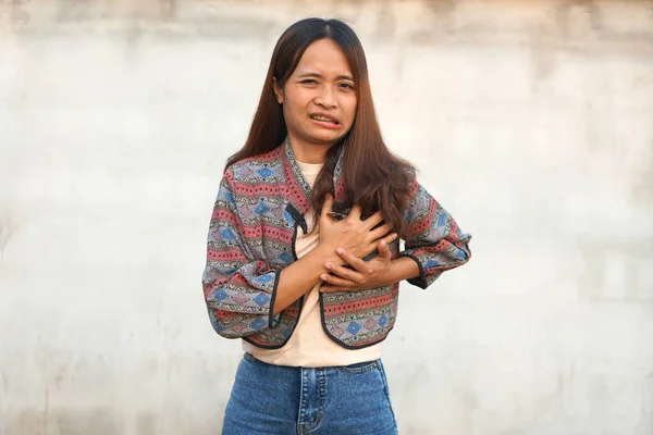 Asian woman having chest tightness, shortness of breath