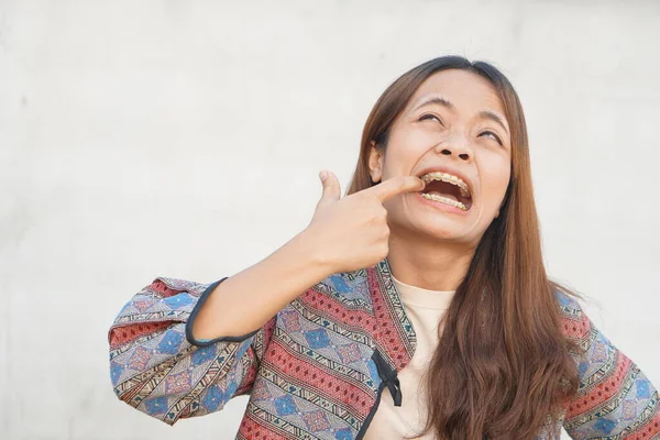 Asian woman having food stuck in her teeth