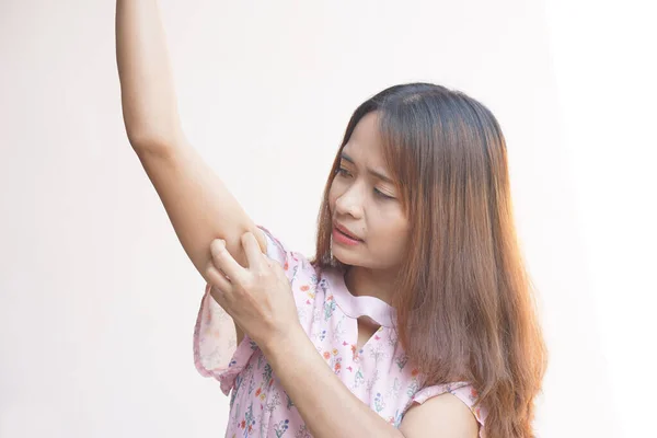 Asian woman having itchy skin on arm