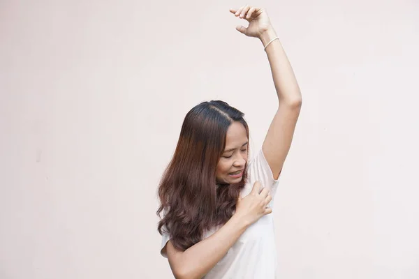 Asian women itching in their armpits