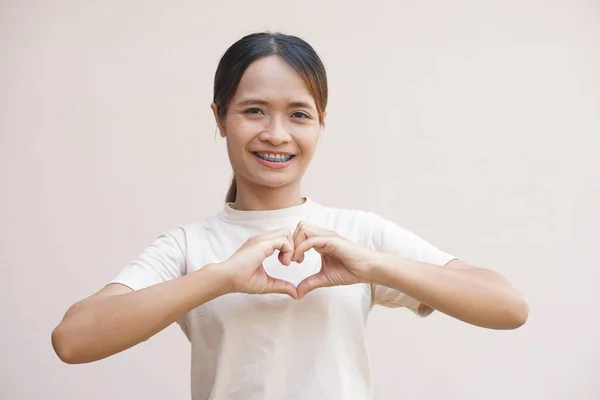 Asian woman making a heart with hands