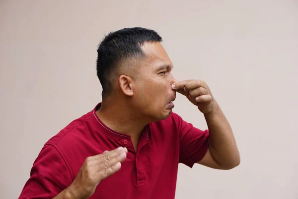 men pinch their noses with their hands to avoid foul odors.