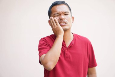 Asyalı adam yemek artıklarından dolayı diş ağrısı çekiyor.
