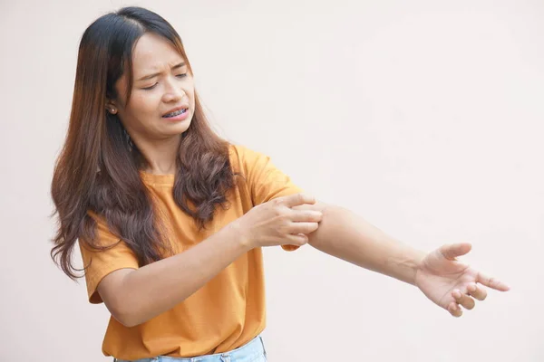 Asian woman having itchy skin on arm