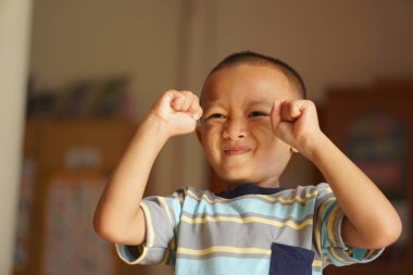 Asyalı çocuk sevinçle el kaldırıyor