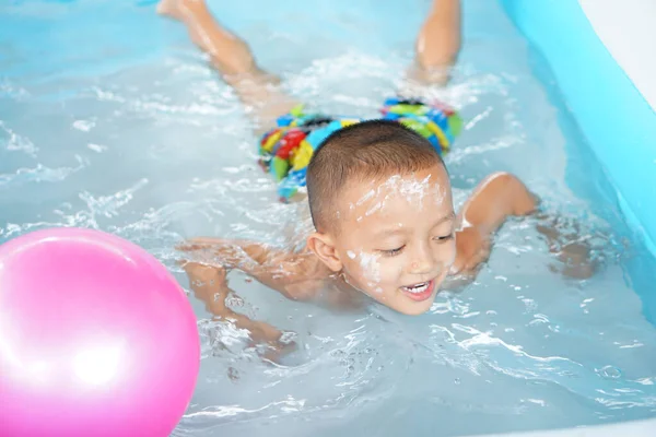 stock image Hot weather. Boy playing with water happily in the tub.