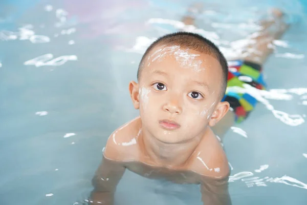 Stock image Hot weather. Boy playing with water happily in the tub.