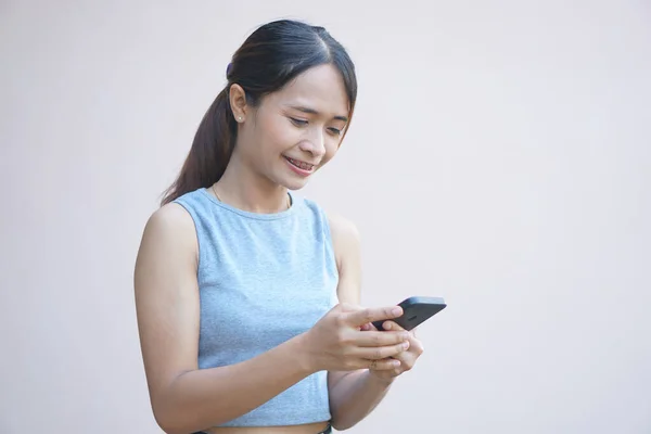 Woman looks at phone and rejoices from more business profit
