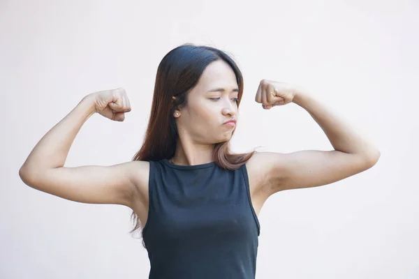 woman flexes her muscles showing her strength