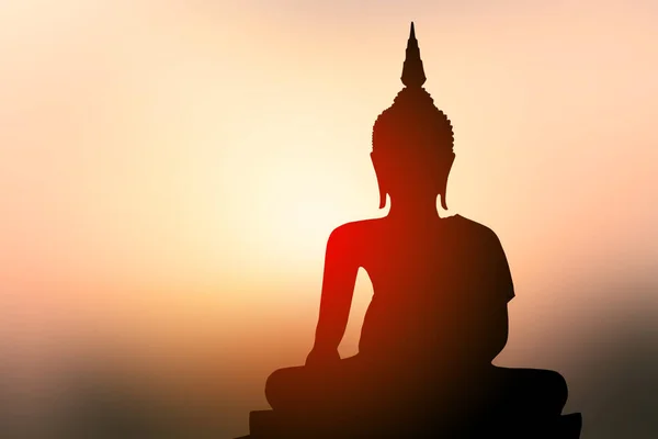 Silhouette Von Buddha Mit Sonne Die Von Hinten Scheint Stockbild