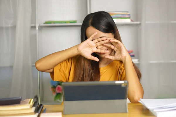 Asian woman at home Having eye pain from watching a computer for a long time