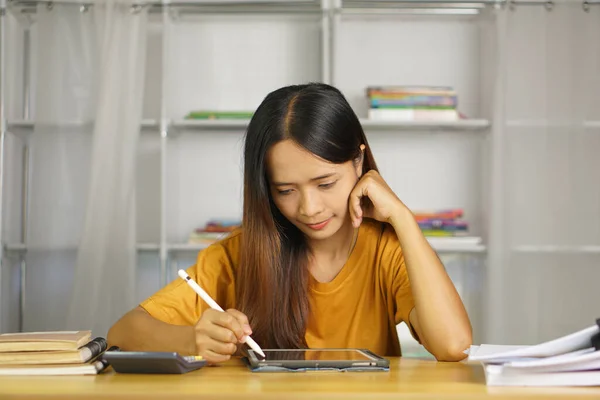 自宅で働くアジアの女性 コンピュータを通じて利益を見るから幸せ ストックフォト