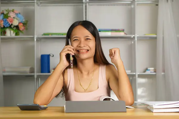 stock image woman working at home Use your phone and computer to communicate with your teammates.