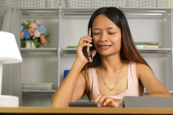 stock image woman working at home Use your phone and computer to communicate with your teammates.