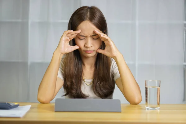 Asian woman working at home Stressed from the loss of business