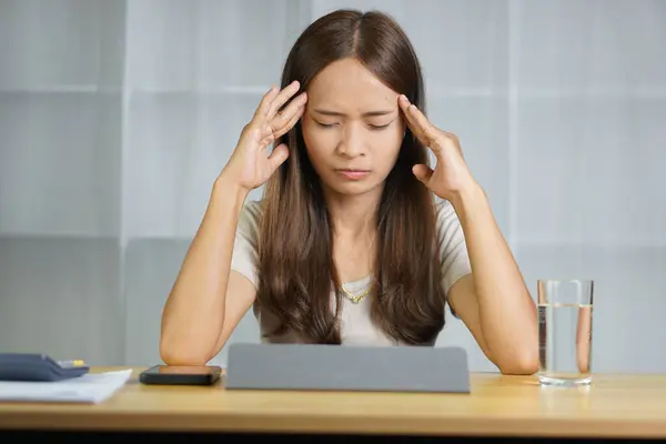 Asian woman working at home Stressed from the loss of business