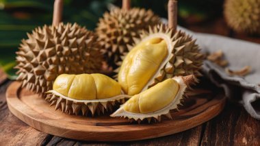 Fresh durian in packaging on wooden dish with durian peel. Durian king of fruit. Tropical fruit. clipart