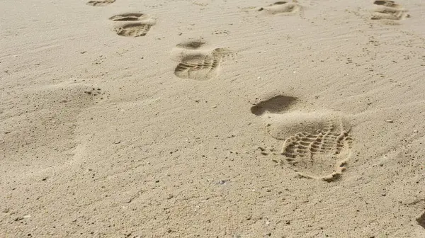 stock image Smooth sand with faint impressions from footprints, creating a subtle and interesting background.