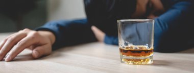 drunk man fall asleep on the table with whiskey glass