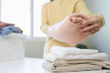 Laundry household work concept, asian woman working on fresh clean clothes.