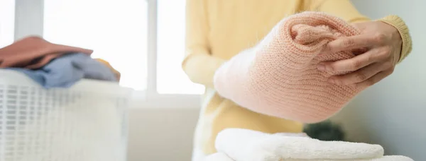 Laundry household work concept, asian woman working on fresh clean clothes.