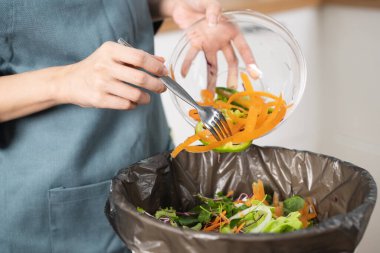 global food pollution concept. Woman throwing a leftover breakfast to the trash.