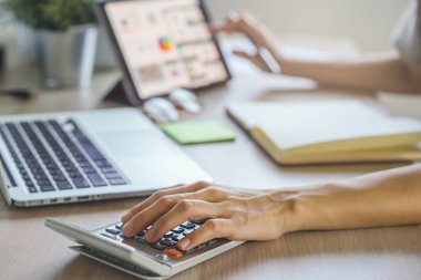 close up hands of accountant calculating tax refund using calculator