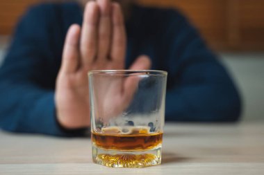 Drunk men deny drinking more glass of whisky by pushing away.