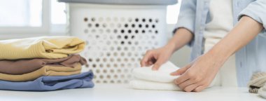 Laundry household work concept, asian woman working on fresh clean clothes.