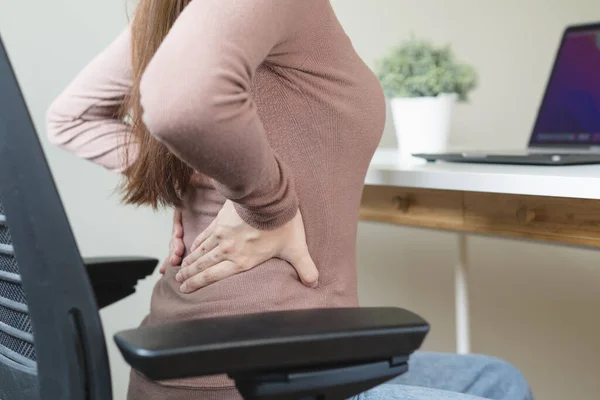 office syndrome, woman with back pain symptoms during work in the office.
